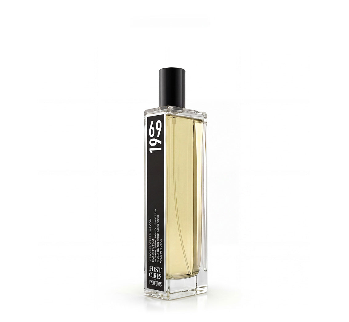A 1969 glass perfume bottle with a black cap on a white background.